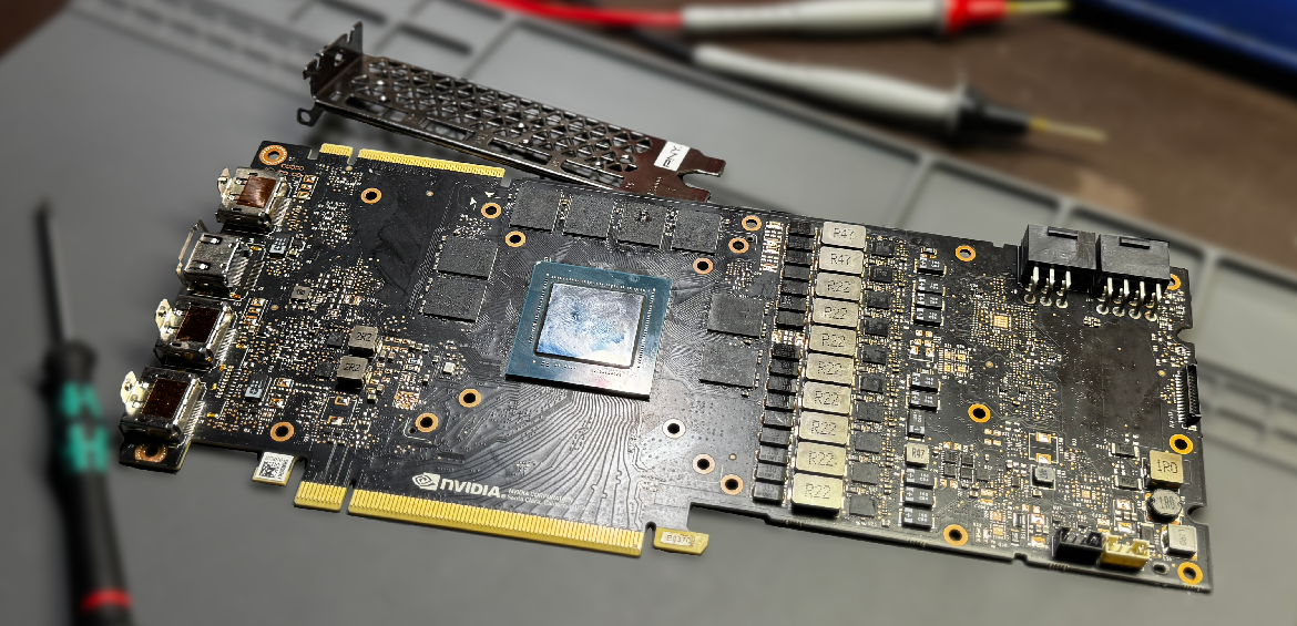 Bare GPU graphics card on workbench with multimeter probes for diagnostic testing in Spokane